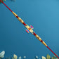 Damru Rakhi With Beads And Floral Detailing