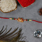 Golden Elephant Rakhi With Red Green Moti